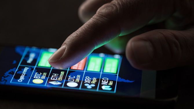 2018年7月25日、スマートフォンのディスプレイで暗号通貨の為替とドルのレートを確認する男性