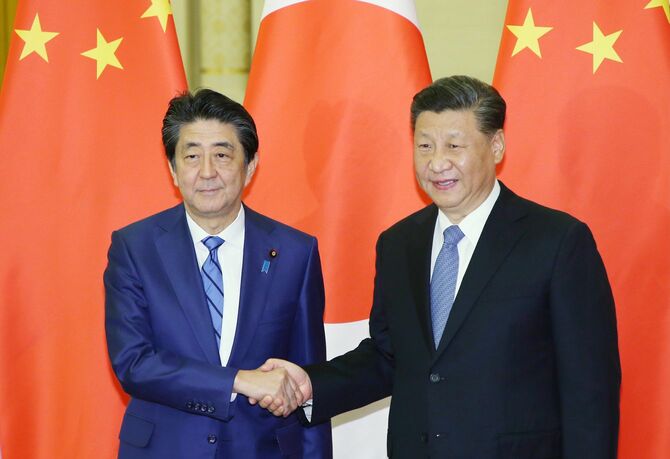 会談を前に握手する安倍晋三首相（左・当時）と中国の習近平国家主席
