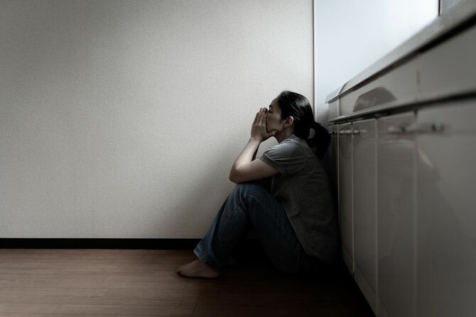台所に座っている絶望的な女性
