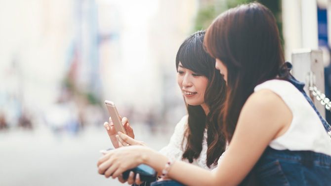 スマートフォンを使用する若い女性二人