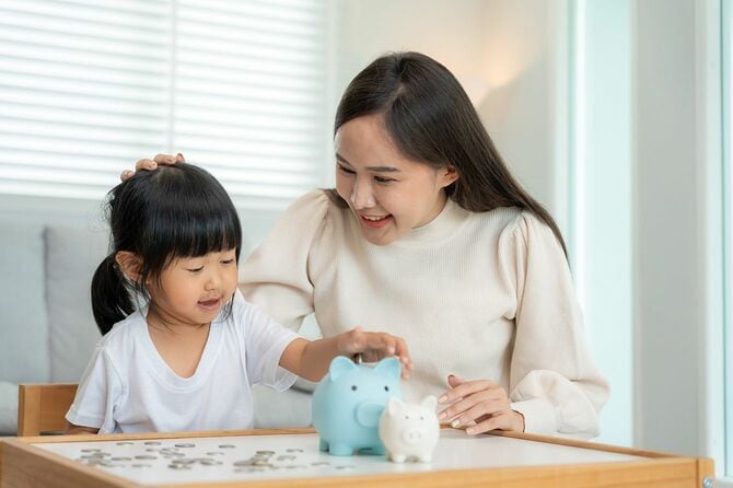 母は娘に貯金を教えている