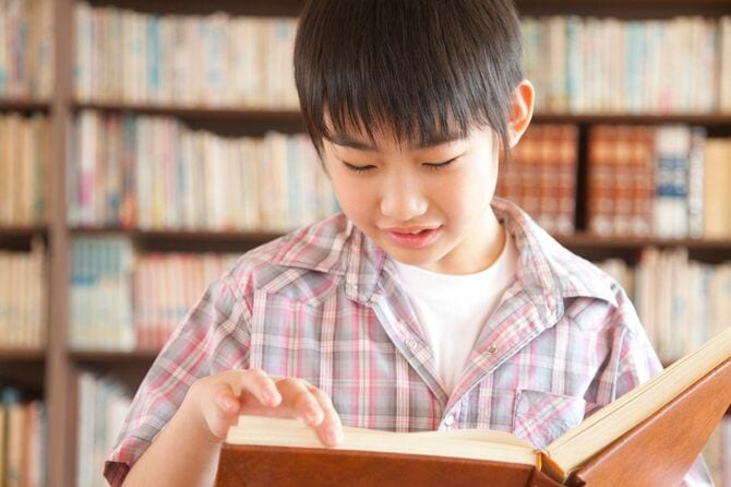 図書室で本を読む少年