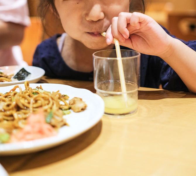 飲食店でジュースを飲む子供