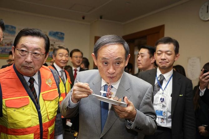 「自然と農山村を守る狩猟のつどい」でジビエのフレンチ料理を試食する菅義偉官房長官（中央）。左は大日本猟友会の佐々木洋平会長