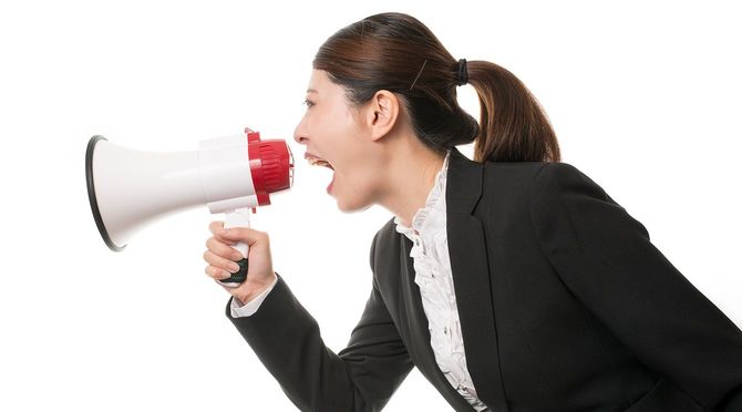 メガホンを使用して叫ぶスーツの女性