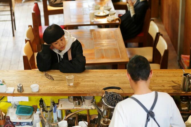京都・鴨川近くの「かもがわカフェ」には修業時代から通っている。「うちのお客さんは、みんな応援してますよ」と、オーナーの高山大輔（写真手前）。二葉は「大ちゃん」と呼ぶ（撮影／武藤奈緒美）