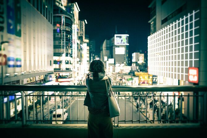 一人で都会の夜景を眺めている女性