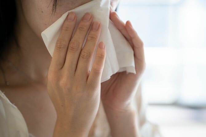 鼻をかむ女性の手元