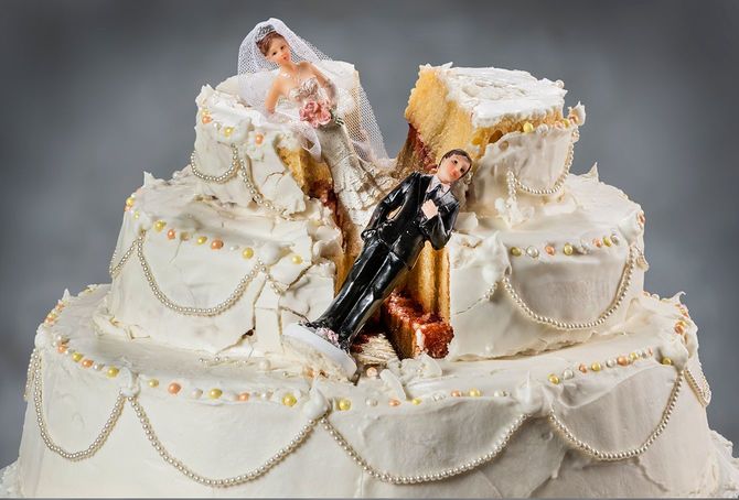 崩れたウェディングケーキの上に新郎新婦の人形