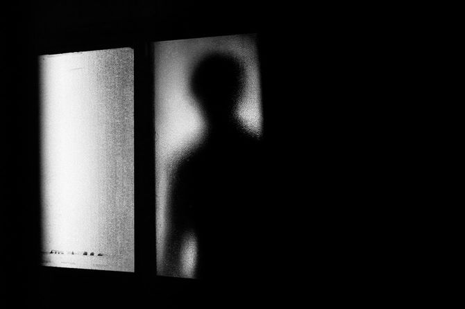 窓からのぞいている男のシルエット