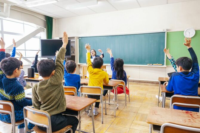 教室で手を挙げる子供たち