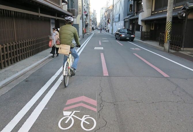 自転車ピクトグラムに従って道路を走行する自転車