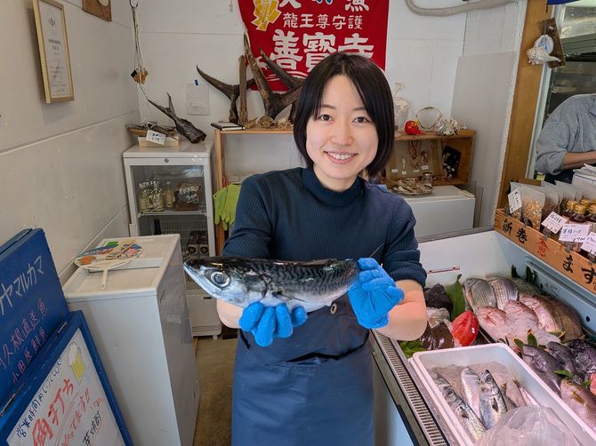 サカナヤマルカマで魚を学ぶボランティアスタッフが持つ600グラム超のサバ