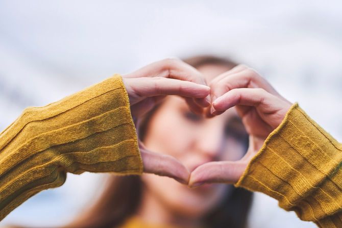 手でハートを作る女性