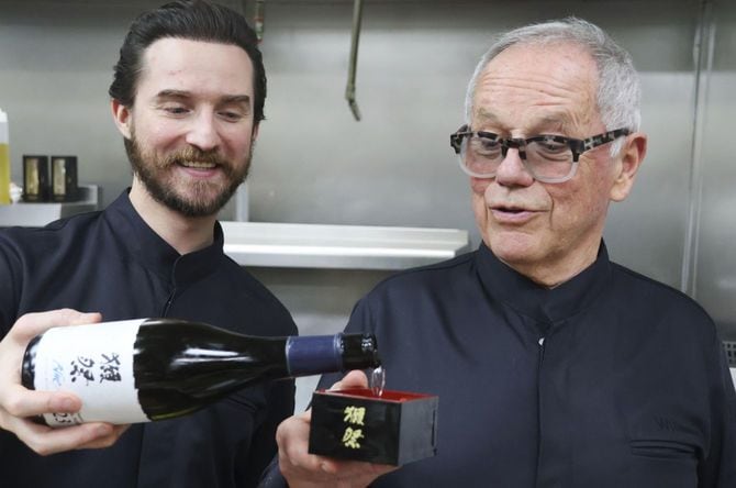 2025年2月27日、米ロサンゼルスで、ウルフギャング・パックさん(右)に清酒「獺祭ブルー」を注ぐ息子のバイロンさん