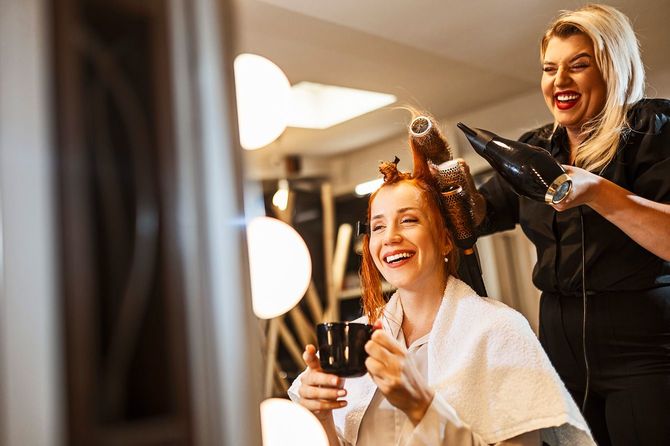 ドライヤーで客の髪をカールする美容師