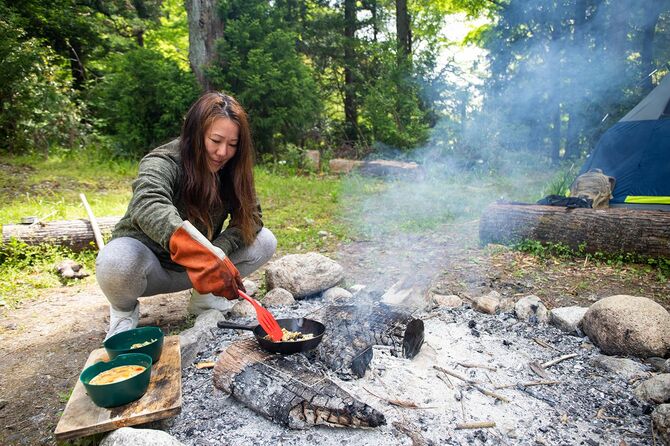 荒野で調理する女性キャンプの火