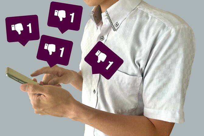スマホで低評価をしている男の手