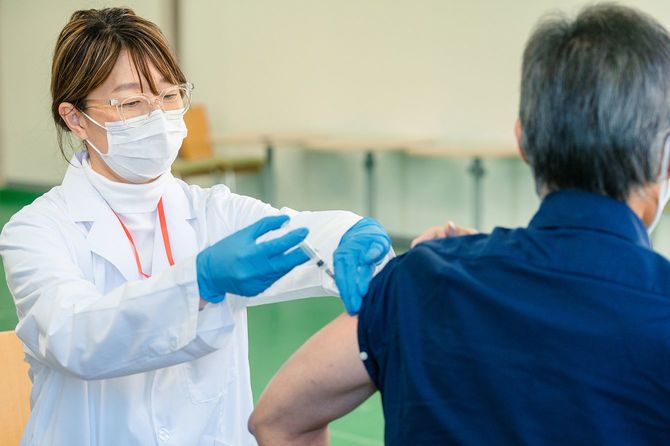 予防接種センターで予防接種を受ける先輩男性