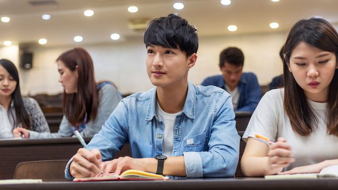 真剣に授業を受ける大学生