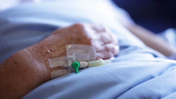 カテーテルがつけられた、高齢女性の手