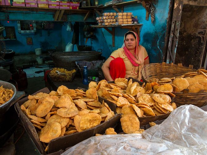 インドニューデリーの市場でスナックを販売する女性