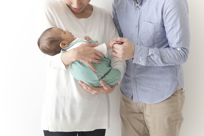 乳児を抱いているカップル