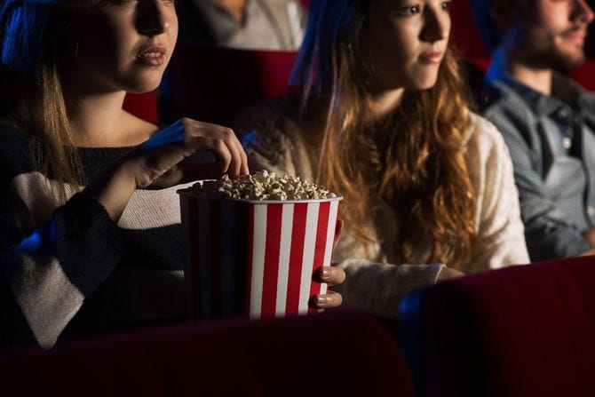 映画館でティーンエイジャーの友人が一緒に映画を見る