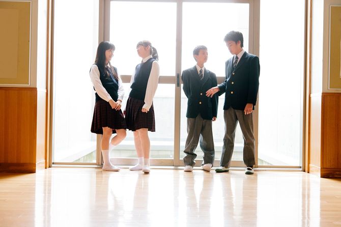 若い生徒たちは学校の廊下でおしゃべりをする