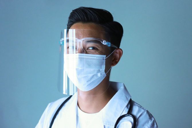 不織布マスクのうえにシールドを着用した医師