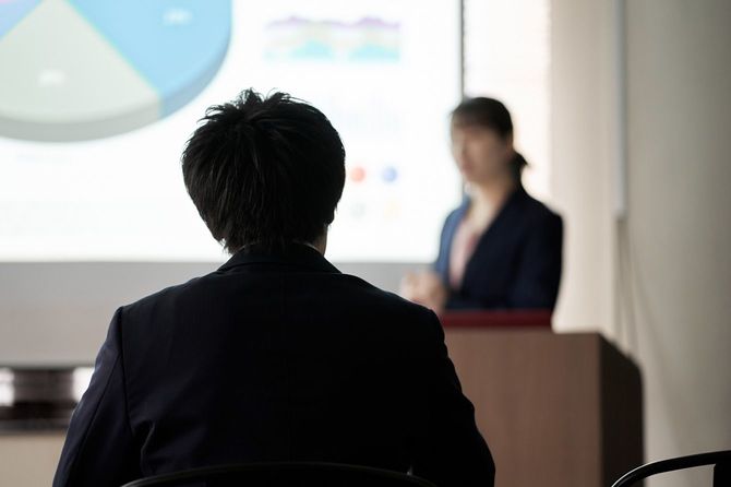 会議で発表を聞くビジネスマン