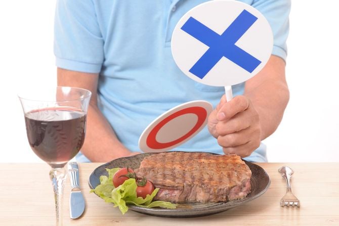 ステーキプレートにバツ印の回答札を出す男性の手元