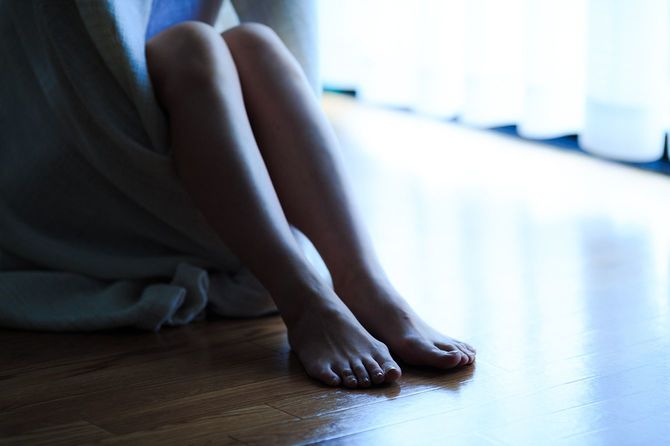 窓際に座って孤独な女性