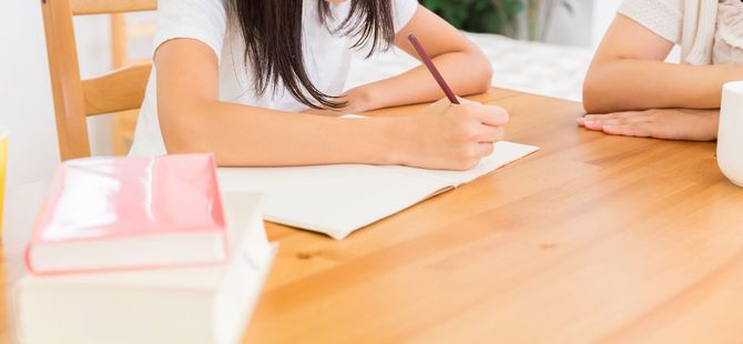 勉強する娘とそれを見守る母親