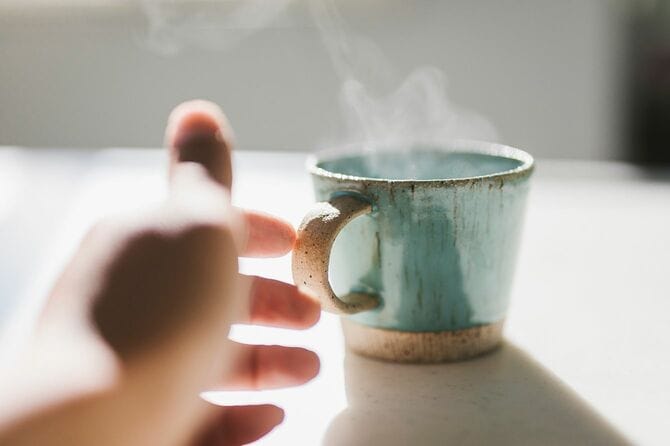 コーヒーカップに触れる男の手