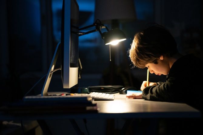 暗闇の中で勉強している小学生