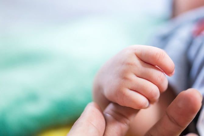 母親の指を握る赤ちゃん