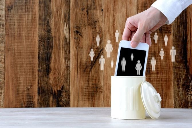 人のピクトグラムに囲まれたスマートフォンをゴミ箱に入れるイメージ