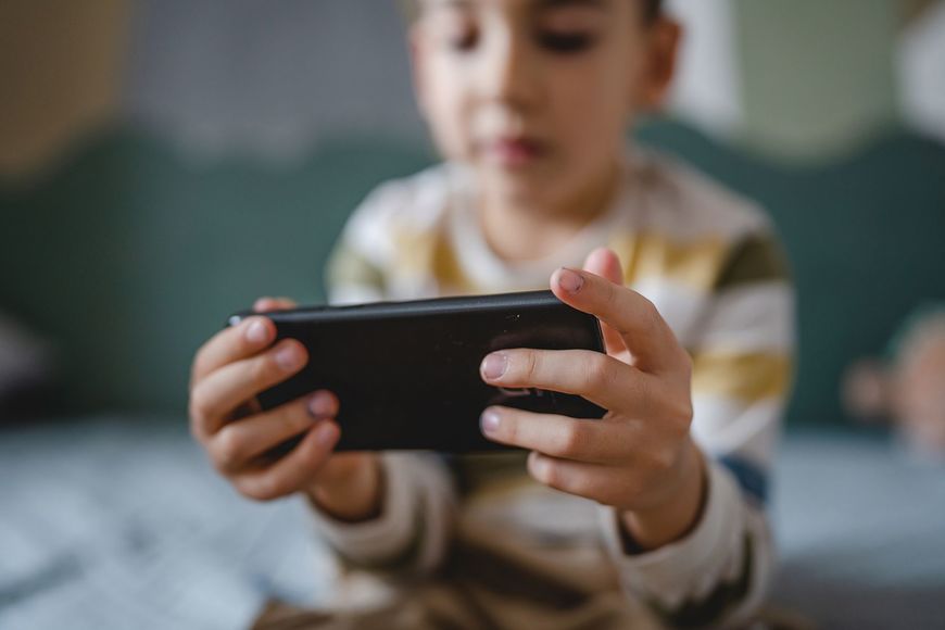 スマホでゲームをする子供