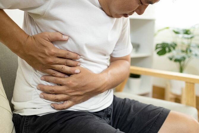 右側の腹の腹痛を有するアジアの男性患者
