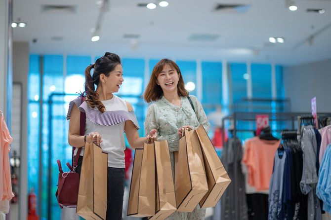 ショッピングで紙袋をたくさん持っている女性たち
