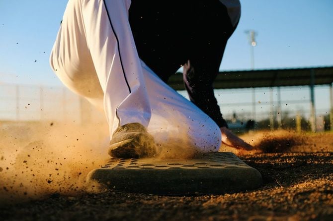 ベースにスライディングする野球選手