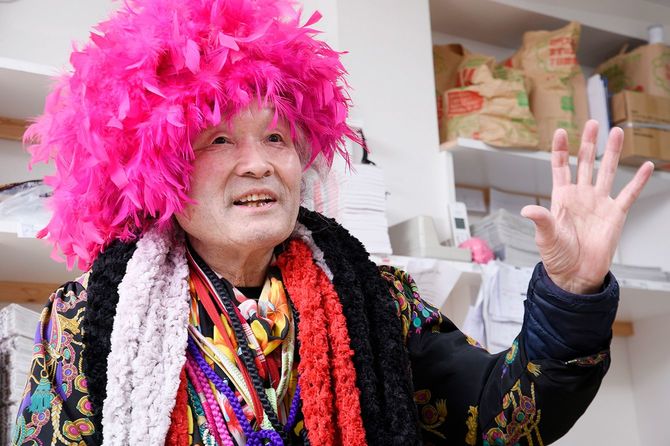 ピンクアフロのカツラで話す男性