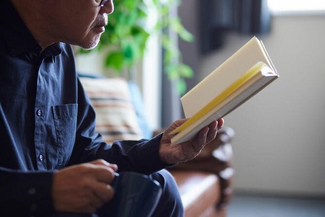 リビングで本を読む高齢男性
