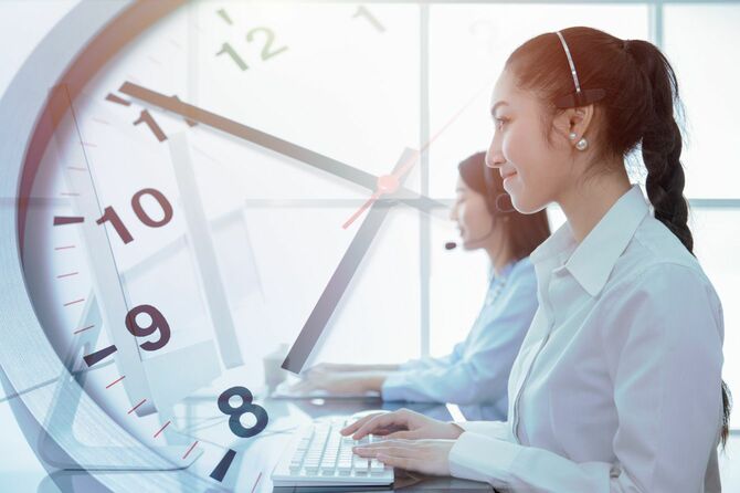 カスタマーセンターのスタッフと背景の時計