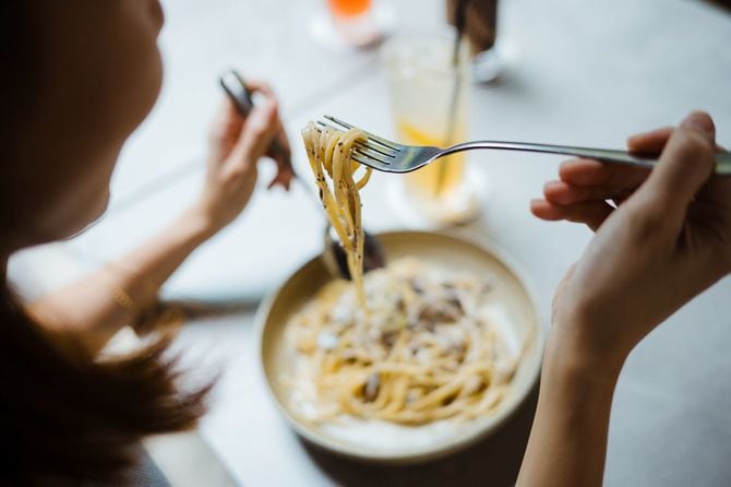 カルボナーラスパゲッティを食べる女性