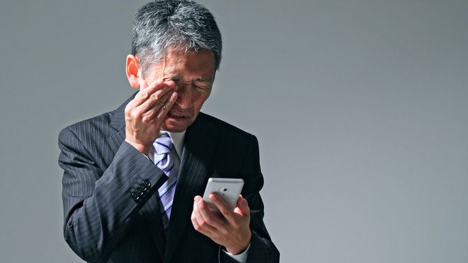 目をこするビジネスマン