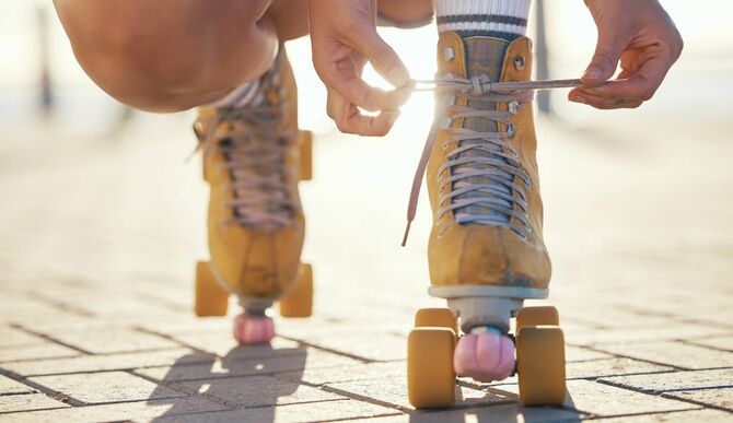 ローラースケート靴の靴紐を結んでいる少年