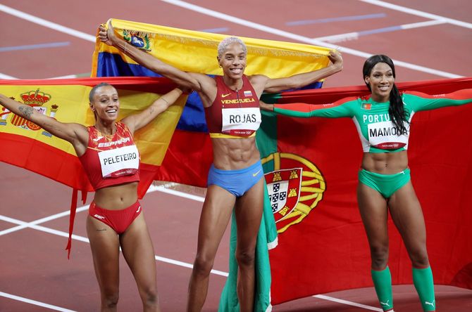 陸上女子三段跳びを世界新記録で制したベネズエラのユリマル・ロハス（中央）ら＝2021年8月1日、東京・国立競技場