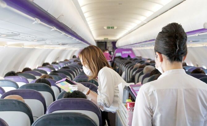 新千歳—那覇線の機内。乗車率は88％に達し、客室乗務員はあわただしい